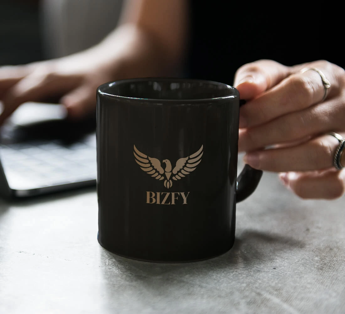 Maketa hrnčeka so značkou Bizfy, ktorá ilustruje identitu značky praktickým a vizuálne príťažlivým spôsobom.
